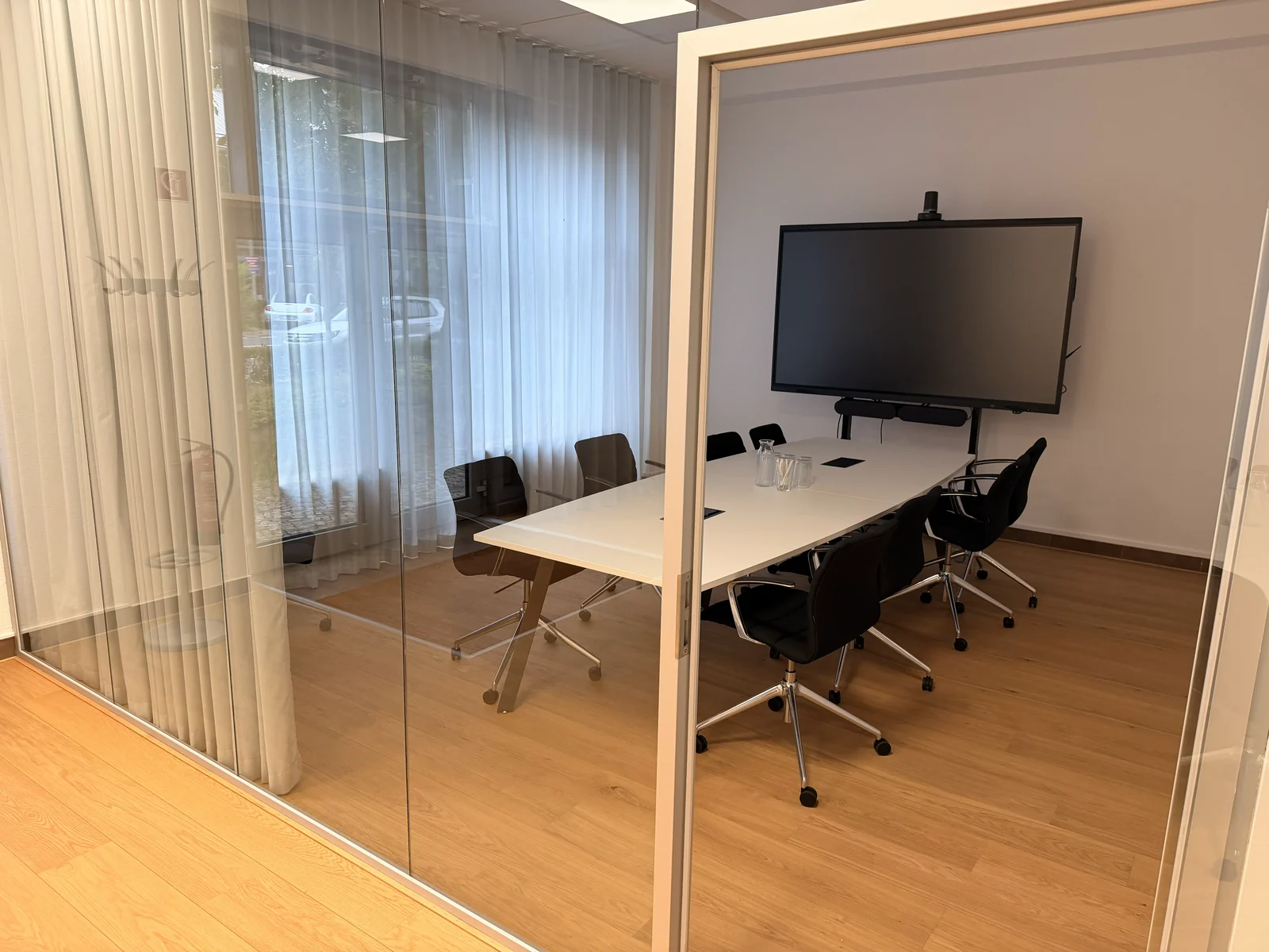 Meeting room with glass partitions and a wooden floor