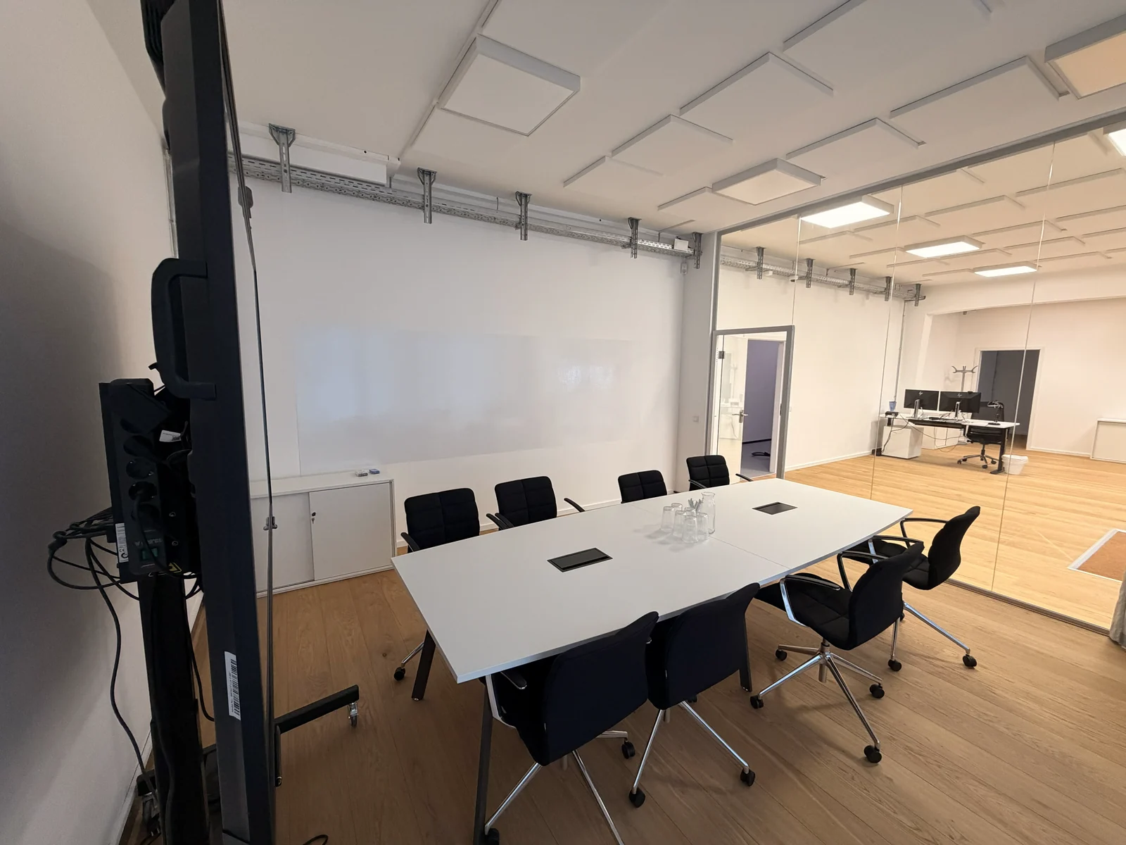 Besprechungsraum mit Konferenztisch und angrenzendem Bürobereich